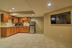 A kitchen with wooden cabinets, a stainless steel refrigerator, a microwave, and a window. - CO Springs Apartment < 6 Mi to Garden of the Gods! (Colorado Springs)