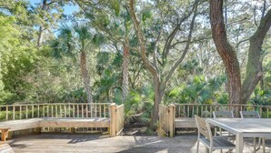 A wooden deck with a table and benches, surrounded by trees and greenery. - Spacious Kiawah Island Home w/ Deck, Walk to Beach (Kiawah Island)
