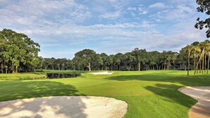 A golf course with sand bunkers, a pond, and dense trees. - Spacious Kiawah Island Home w/ Deck, Walk to Beach (Kiawah Island)
