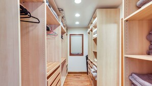 A narrow walk-through closet with wooden shelves and a central window. - Spacious Kiawah Island Home w/ Deck, Walk to Beach (Kiawah Island)