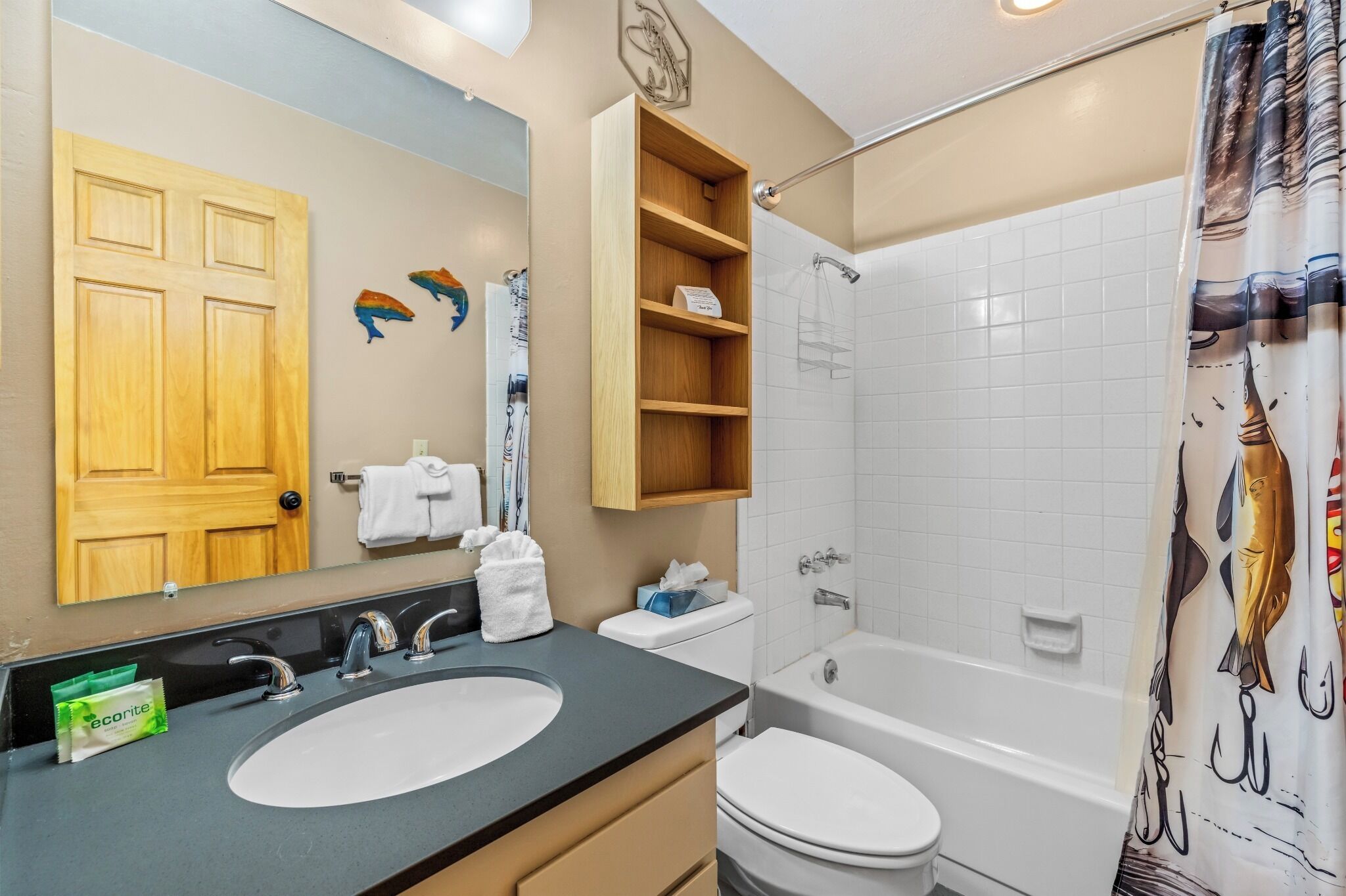 A bathroom with a double sink, toilet, bathtub, and shower curtain.