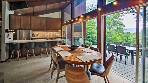Una cocina moderna con armarios de madera, un refrigerador de acero inoxidable y una isla grande con taburetes de bar.
