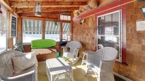 A cozy wooden interior with wicker furniture, a rocking chair, and large windows overlooking a snowy landscape. - Chester Farmhouse on 100 Acres, 15 Min to Okemo! (Chester)
