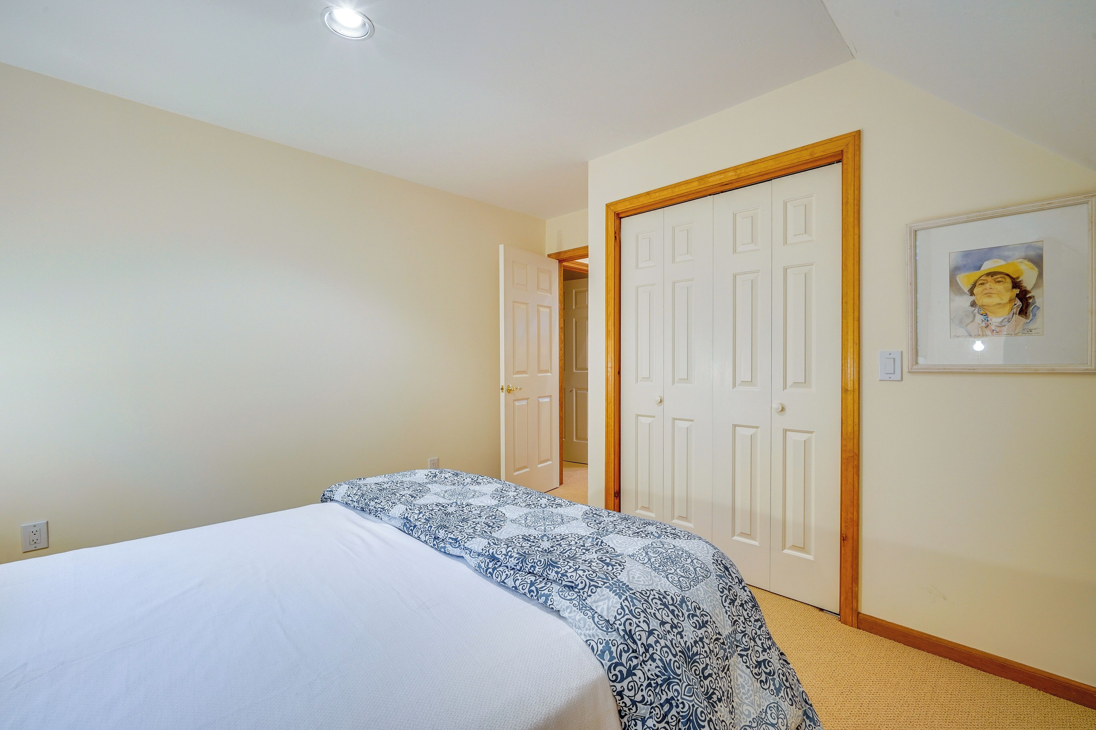 Una camera da letto con un letto, una porta e un quadro appeso al muro.