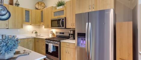 A modern kitchen with wooden cabinets, stainless steel appliances, and a built-in oven.