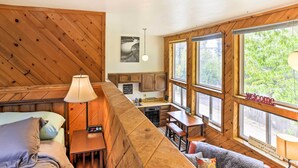 A cabin interior with a loft bed, a kitchen area, and a seating area with a view of the outdoors. - Cozy Studio Near Hiking & Skiing, Walk to Downtown (Mount Shasta)