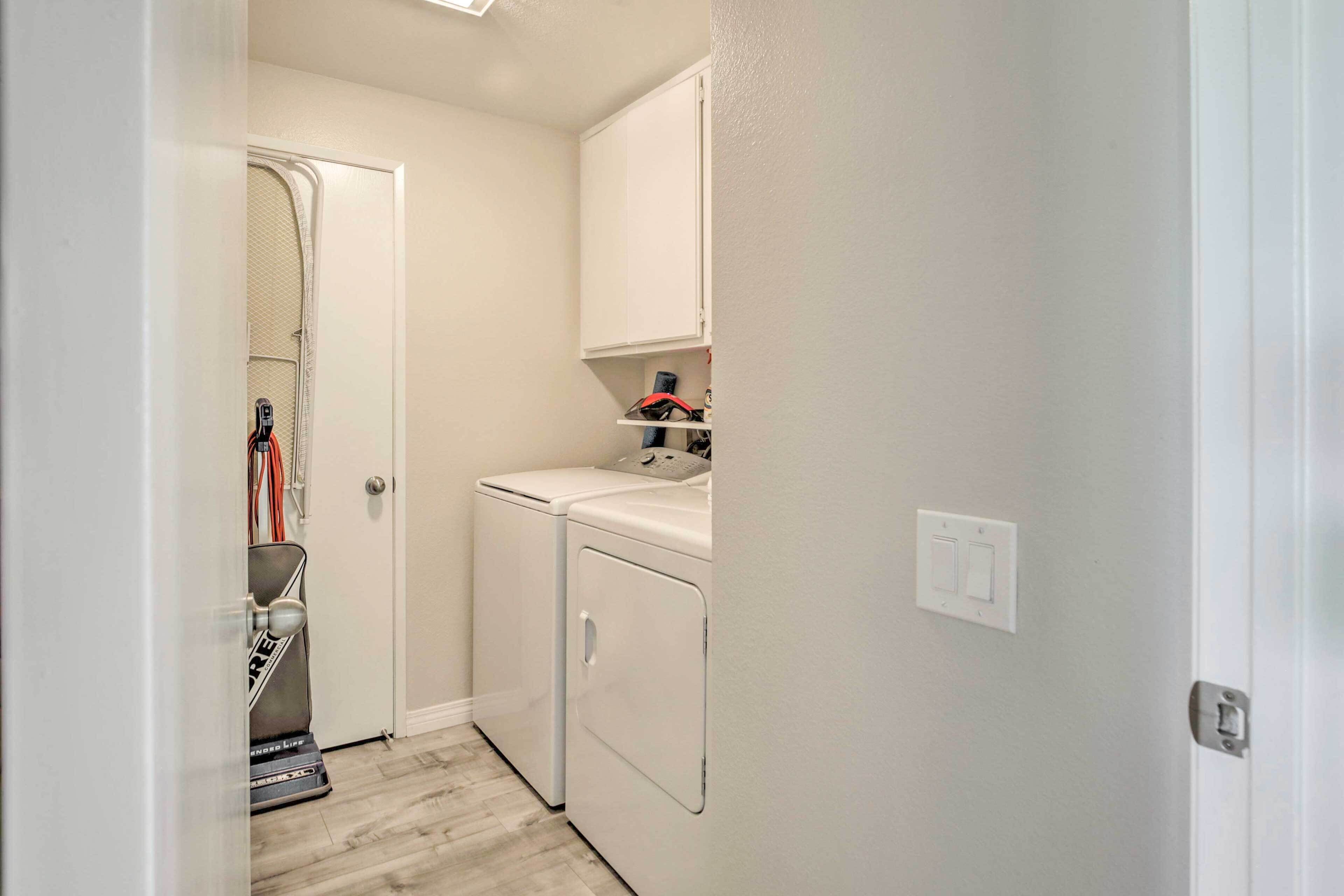 A laundry room with a washing machine, dryer, and a cabinet above the dryer.