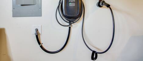 Une boîte électrique fixée au mur, avec un câble relié à une prise.