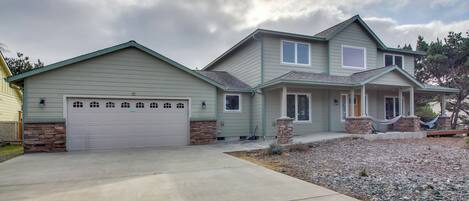 A two-story house with a garage, stone accents, and a covered porch.