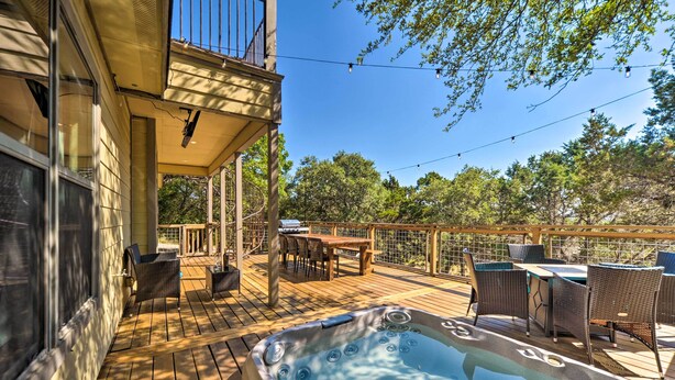 Une terrasse en bois avec un jacuzzi, du mobilier d’extérieur et un espace repas.