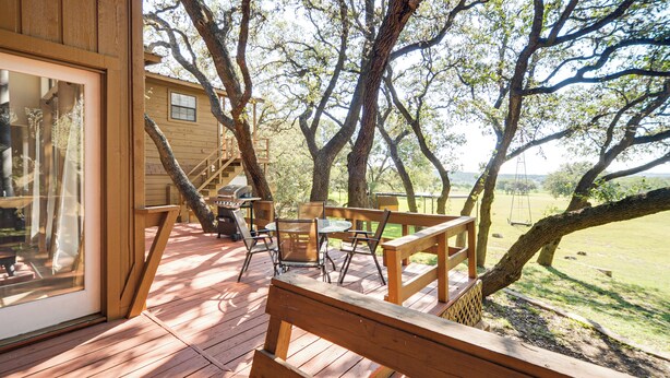 A wooden deck with a table and chairs, overlooking a grassy area with trees. - Canyon Lake House w/ Porch, Views + Private Gazebo (Canyon Lake)