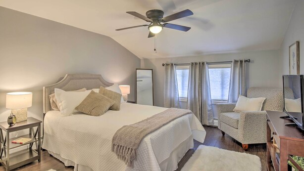 A bedroom with a bed, bedside tables, a ceiling fan, a TV, and a window with curtains. - Stylish Pine Plains Home Near Parks & Hiking! (Pine Plains)