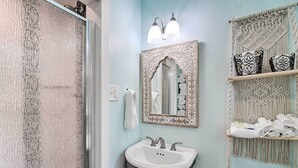 Un bagno con lavandino, specchio e portasciugamani.
