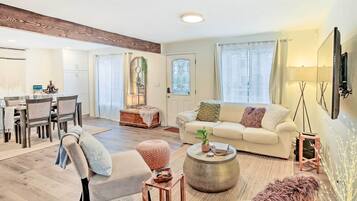 Un salón amplio con un sofá grande, una mesa de centro y un comedor con sillas y una mesa.