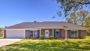 A two-story house with a garage, a front porch, and a well-maintained lawn.