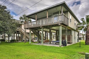 A two-story house with a balcony, a covered porch, and a small lawn area.