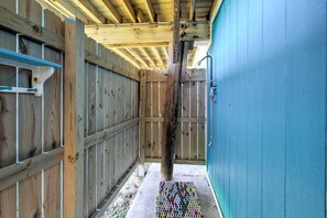 Un corridoio di legno stretto con una porta blu sulla destra e una struttura in legno a sinistra.