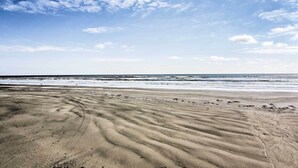 A beach with a clear sky and gentle waves.