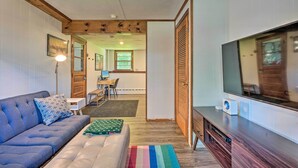 Un salon moderne avec un canapé, un téléviseur et un meuble de rangement en bois.