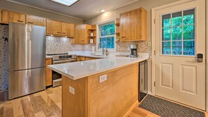 Une cuisine moderne avec des meubles en bois, des appareils en acier inoxydable et un grand îlot central.