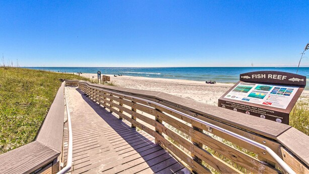 A wooden boardwalk leading to a beach with a sign for a fish reef. - Half-mi to Inlet Beach: Home w/ Grill & Fire Pit (Panama City Beach)