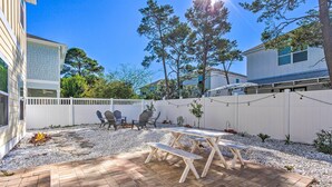 A backyard with a picnic table and chairs, surrounded by a white fence and trees. - Half-mi to Inlet Beach: Home w/ Grill & Fire Pit (Panama City Beach)
