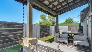 An outdoor patio with a stone bench, a table, and a grill area. - 'uncorked Ranch' Hill Country Home: 1 Mi to Winery (Fredericksburg)