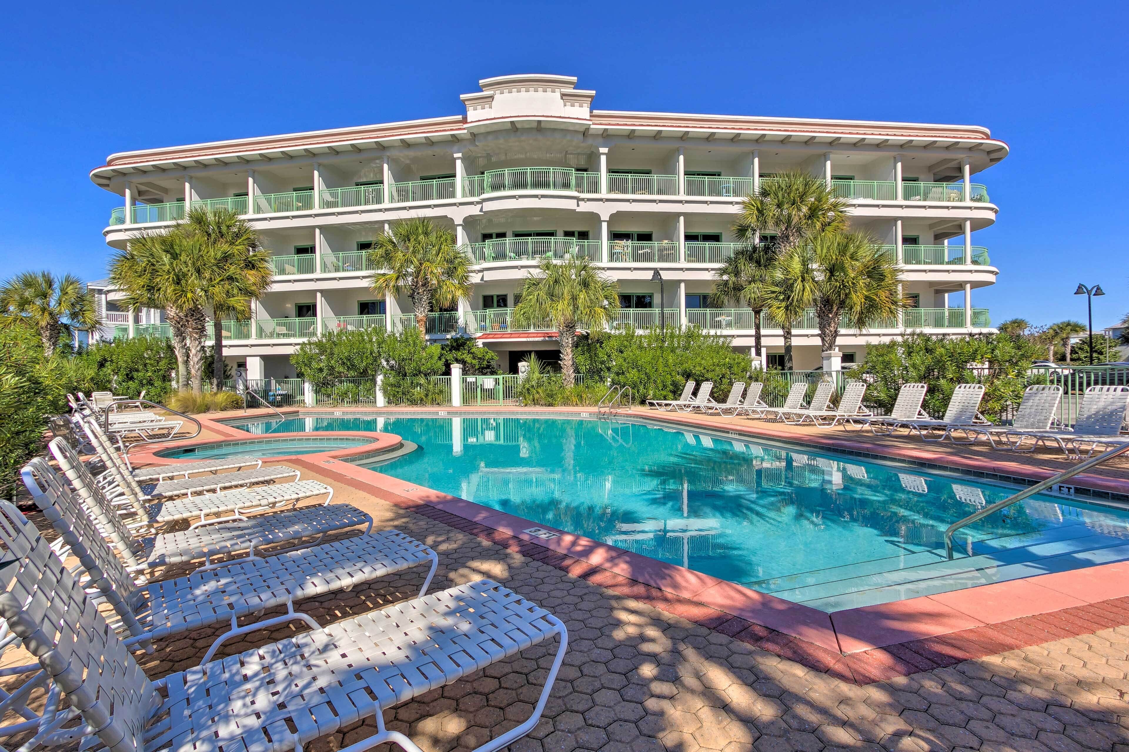 Un hôtel doté d’une piscine, de plusieurs balcons et de palmiers.
