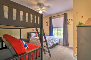 A bedroom with bunk beds, a ceiling fan, a window with curtains, and wall decorations. - Sun-soaked Kissimmee Gem w/ Resort Amenities! (Kissimmee)