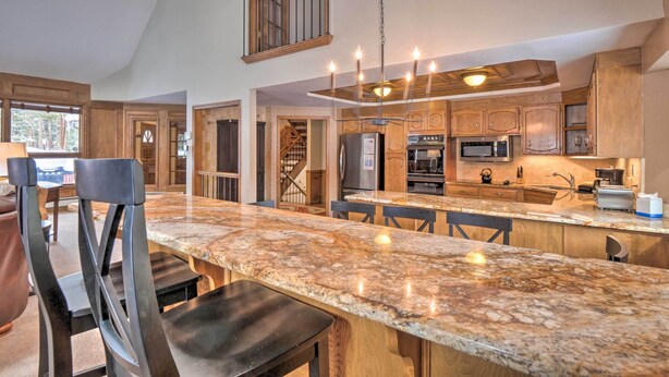 A spacious kitchen with granite countertops, wooden cabinets, and a central island with bar stools. - 2 Mi to Slopes! Hot Tub Hideaway in Breckenridge (Breckenridge)