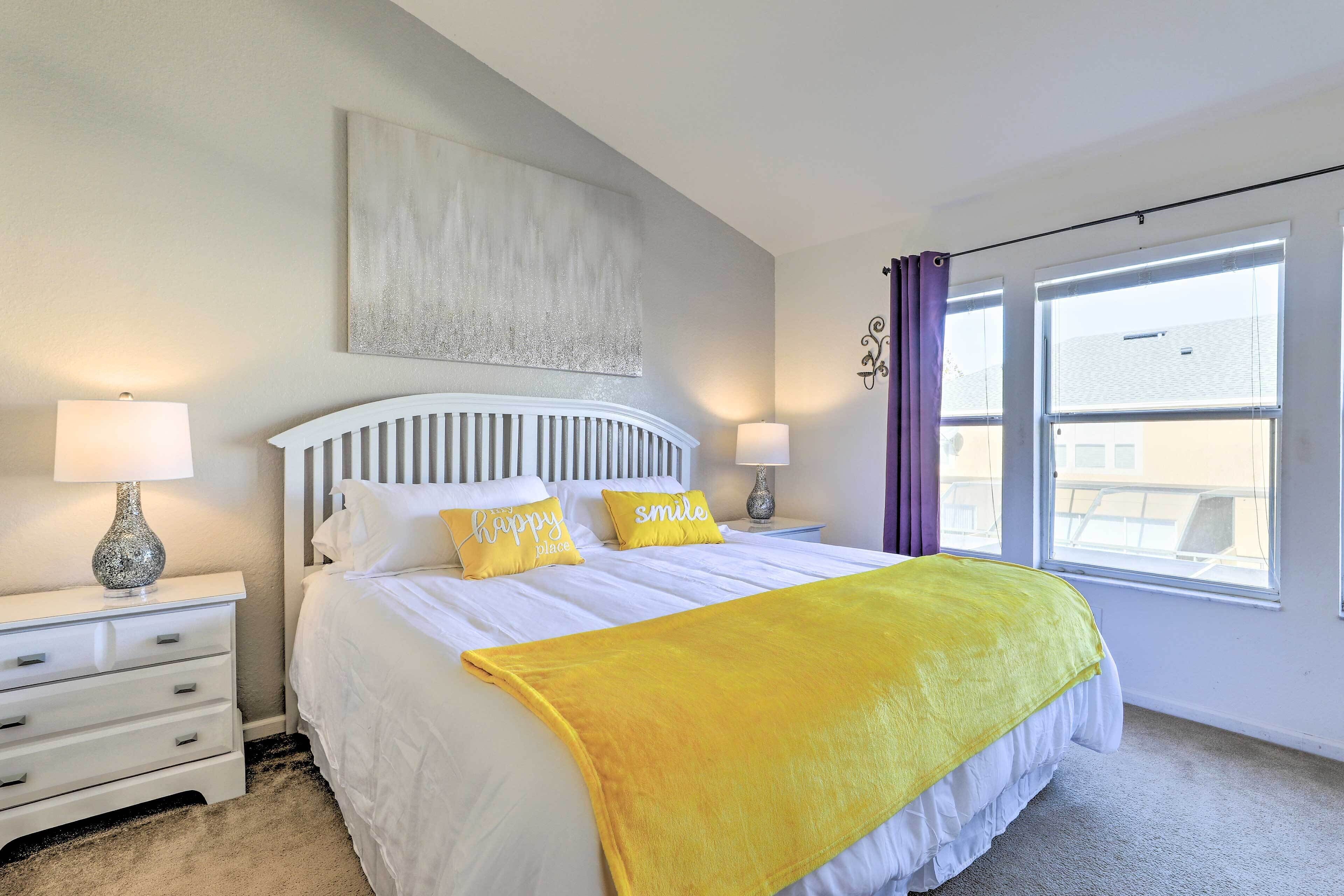 A neatly arranged bedroom with a bed, two bedside tables, and a window with curtains.