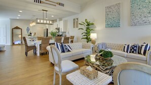 A spacious living room with a large sofa, a dining area with a table and chairs, and a kitchen in the background. - Ocean View Home w/ Beach Shuttle, 5 Mi to Coast! (Frankford)
