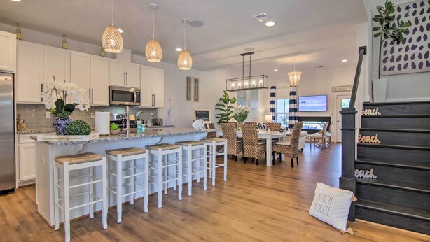 A modern kitchen with white cabinets, a central island with bar stools, and pendant lighting. - Ocean View Home w/ Beach Shuttle, 5 Mi to Coast! (Frankford)