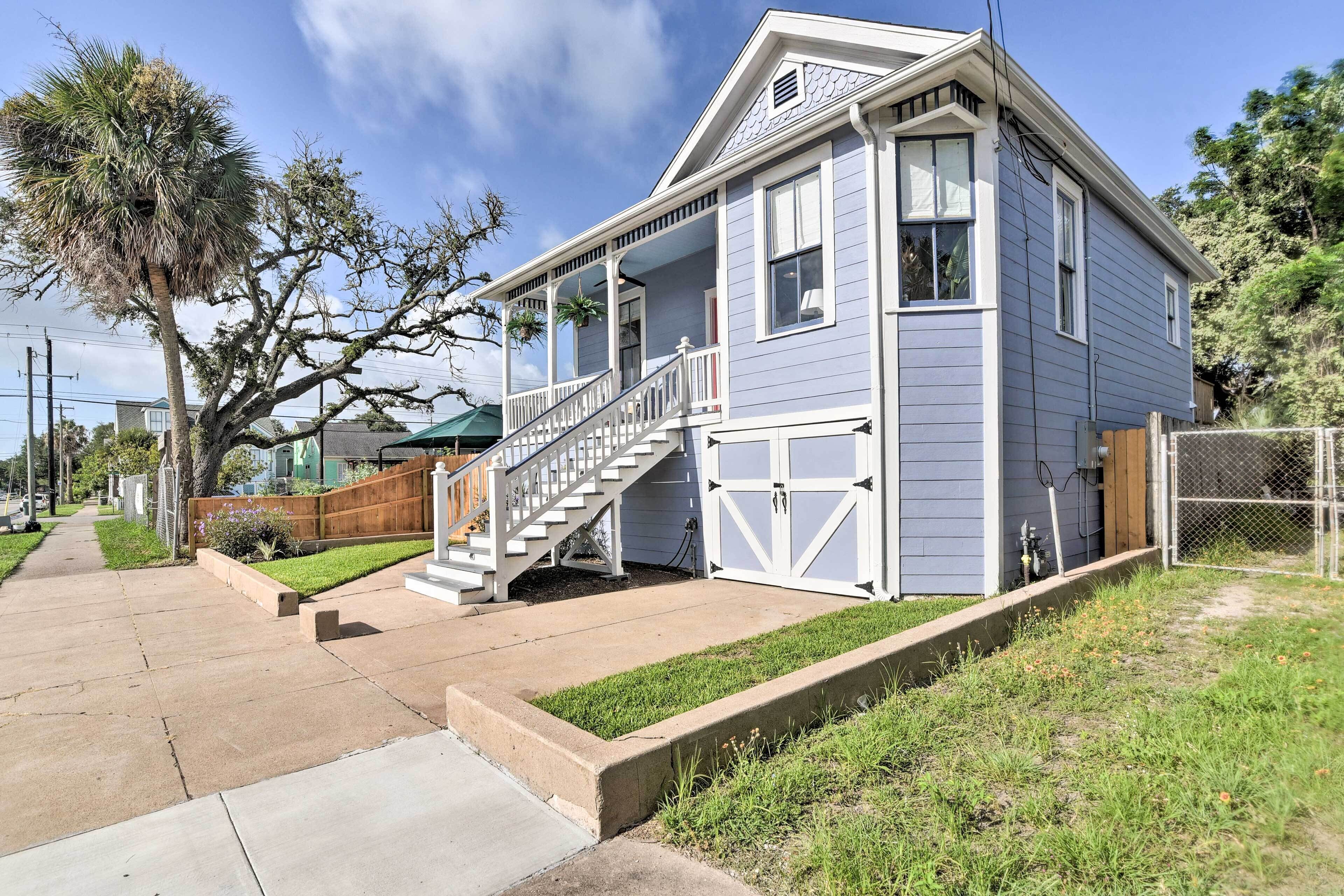 A two-story house with a front porch, a staircase leading to the entrance, and a garage.