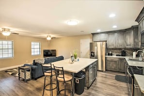 A modern kitchen with a central island, built-in appliances, and a dark wood floor. - Relaxing Pensacola Getaway w/ Volleyball Net! (Pensacola)