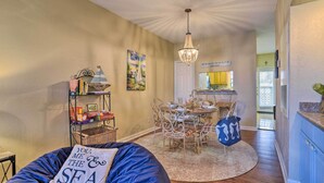 A cozy living room with a blue bean bag, a dining area with a chandelier, and a kitchen visible through an open door. - < 1 Mi to Stewart Beach: Gem in East End Galveston (Galveston)