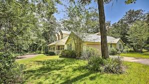 A house with a large front lawn, a covered porch, and a garage. - Charming Waldo Getaway Near Lake Santa Fe! (Waldo)