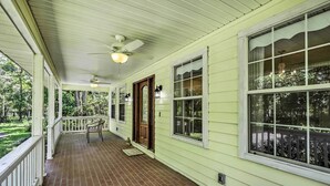 A covered porch with a brick floor, white railings, and a ceiling fan. - Charming Waldo Getaway Near Lake Santa Fe! (Waldo)
