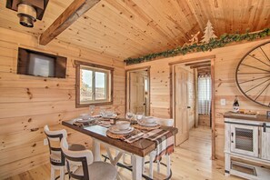 Cozy cabin-style accommodation with a dining area featuring a wooden table and two comfortable chairs.
