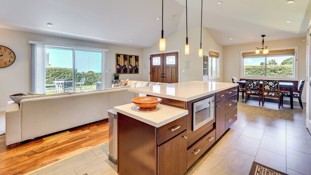 A modern kitchen with a large island, wooden cabinets, and pendant lighting. - Kona Coast Hideaway w/ Patio & Pacific Ocean Views (Kailua-Kona)