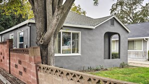 A residential house with a grey exterior, a brick wall, and a small garden area. - Cozy Elk Grove Home in the Heart of Old Town! (Elk Grove)
