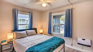 A bedroom with a bed, bedside tables, a heater, and curtains. - Cozy Elk Grove Home in the Heart of Old Town! (Elk Grove)