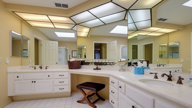 A modern bathroom with a large mirror, two sinks, and a vanity with drawers and cabinets. - Golf Resort Getaway w/ Pool Access in Palm Desert (Palm Desert)
