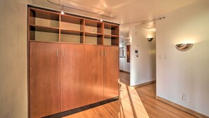 A hallway with a wooden wardrobe, a light fixture, and a wall-mounted light. - Tulsa Rental Home - Walk to Philbrook Museum (Tulsa)