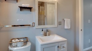 A bathroom with a toilet, sink, mirror, and towel rack. - Charming Baltimore Getaway - 5 Miles to Downtown! (Baltimore)