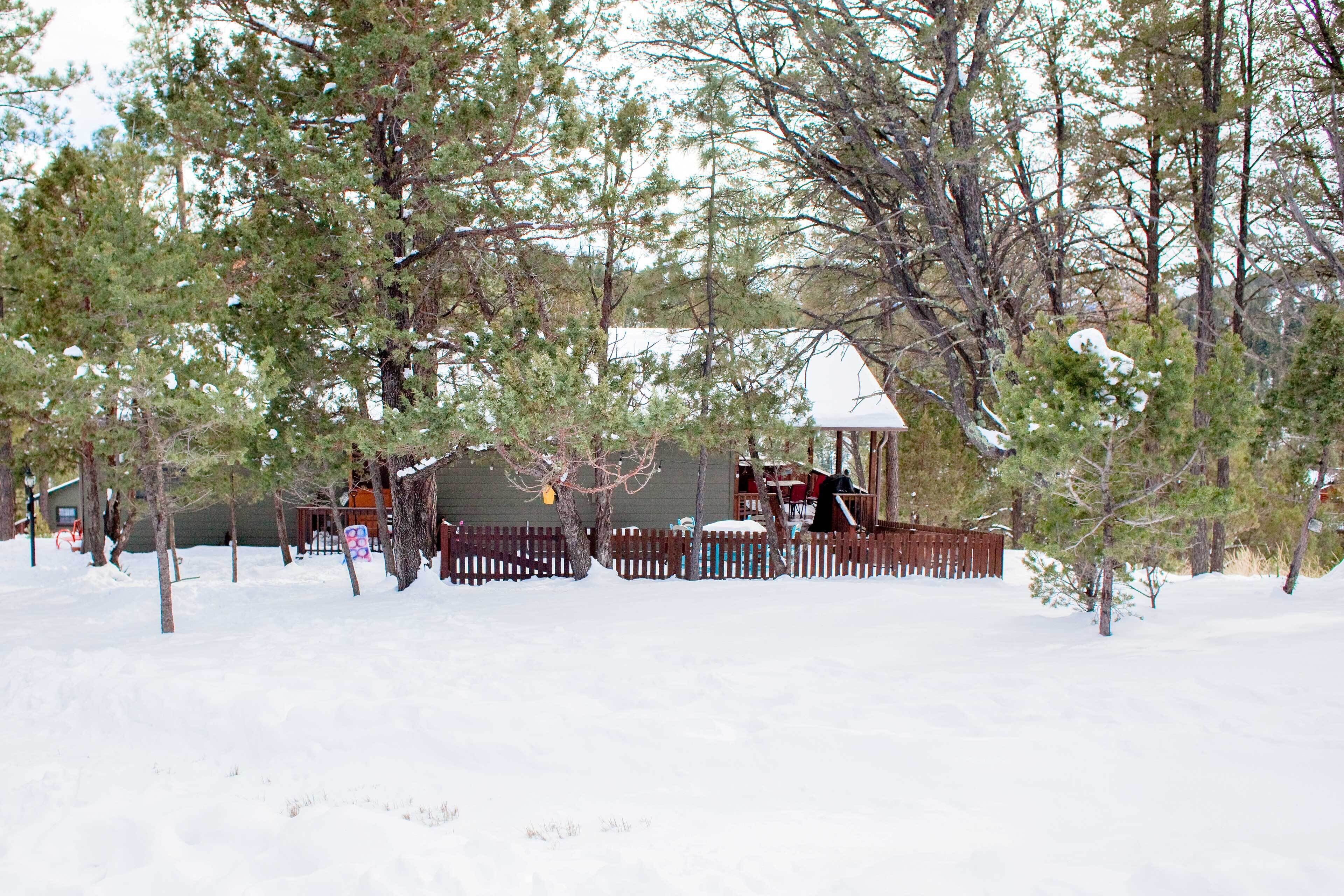 A snow-covered outdoor area with a wooden deck and a small gazebo.