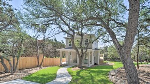A two-story house with a covered patio, surrounded by trees and a wooden fence. - Canyon Lake Home w/ Deck ~ 1 Mi to Comal Park (Canyon Lake)