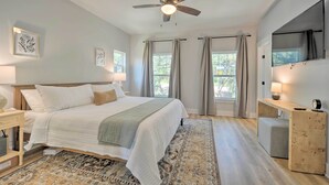A bedroom with a bed, bedside tables, a ceiling fan, a desk, and a TV. - Canyon Lake Home w/ Deck ~ 1 Mi to Comal Park (Canyon Lake)