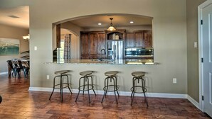 Une cuisine dotée d’un îlot central, de tabourets de bar et d’un coin repas avec des chaises.