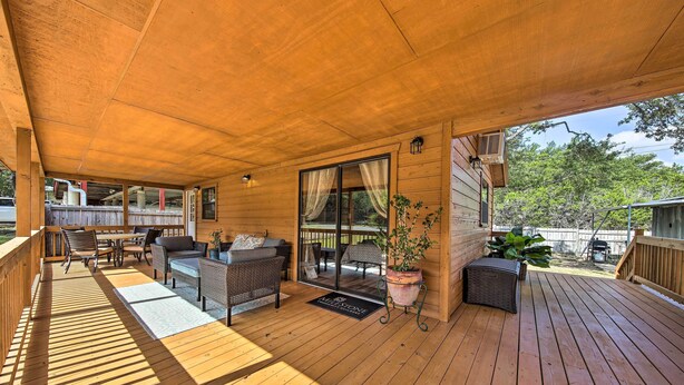 A wooden deck with outdoor furniture, a sliding glass door, and a potted plant.